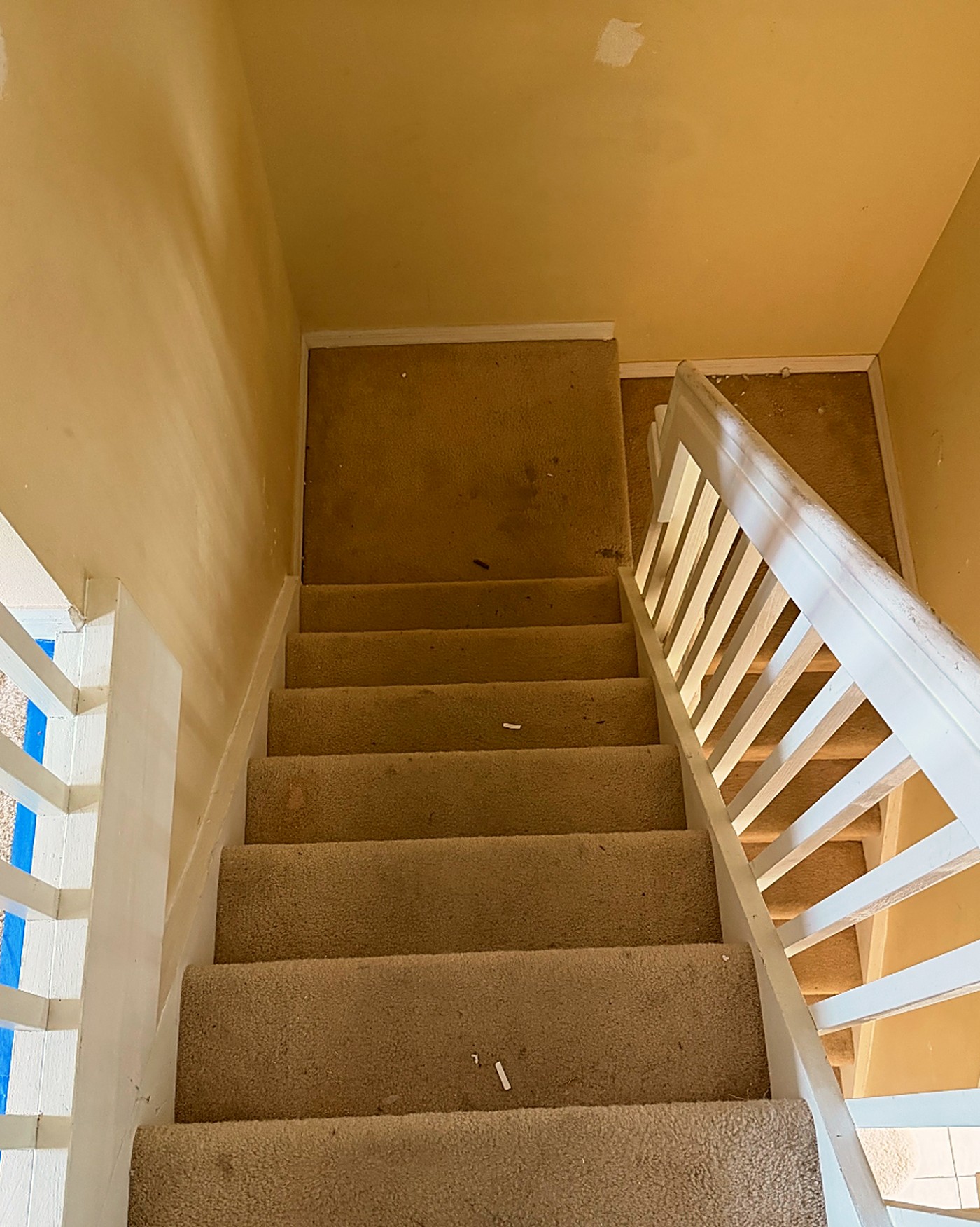Worn beige carpet staircase before renovation